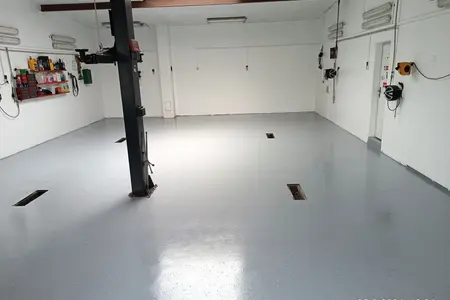 Autoservis. Epoxidová stěrka v barvě RAL 7001 pohozená akrylátovým černobílým chipsem